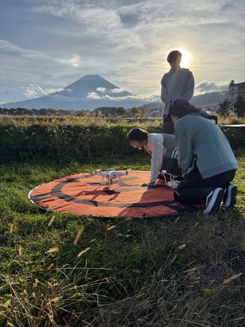 富士山を背景に、ドローン操作を楽しむご家族の姿